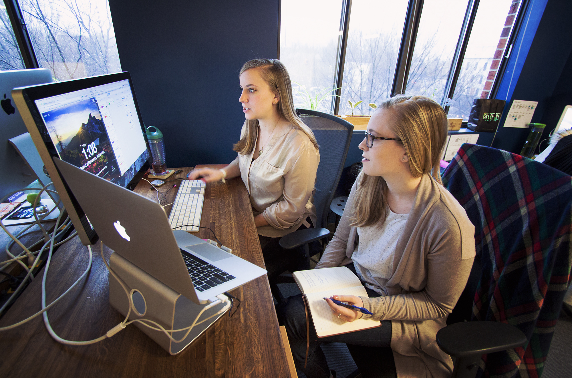 Amanda and Becca are PMs at Viget. They're sitting at a table reviewing project tasks.